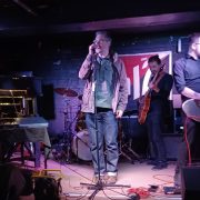 Music band. Man singing. Two men playing guitar